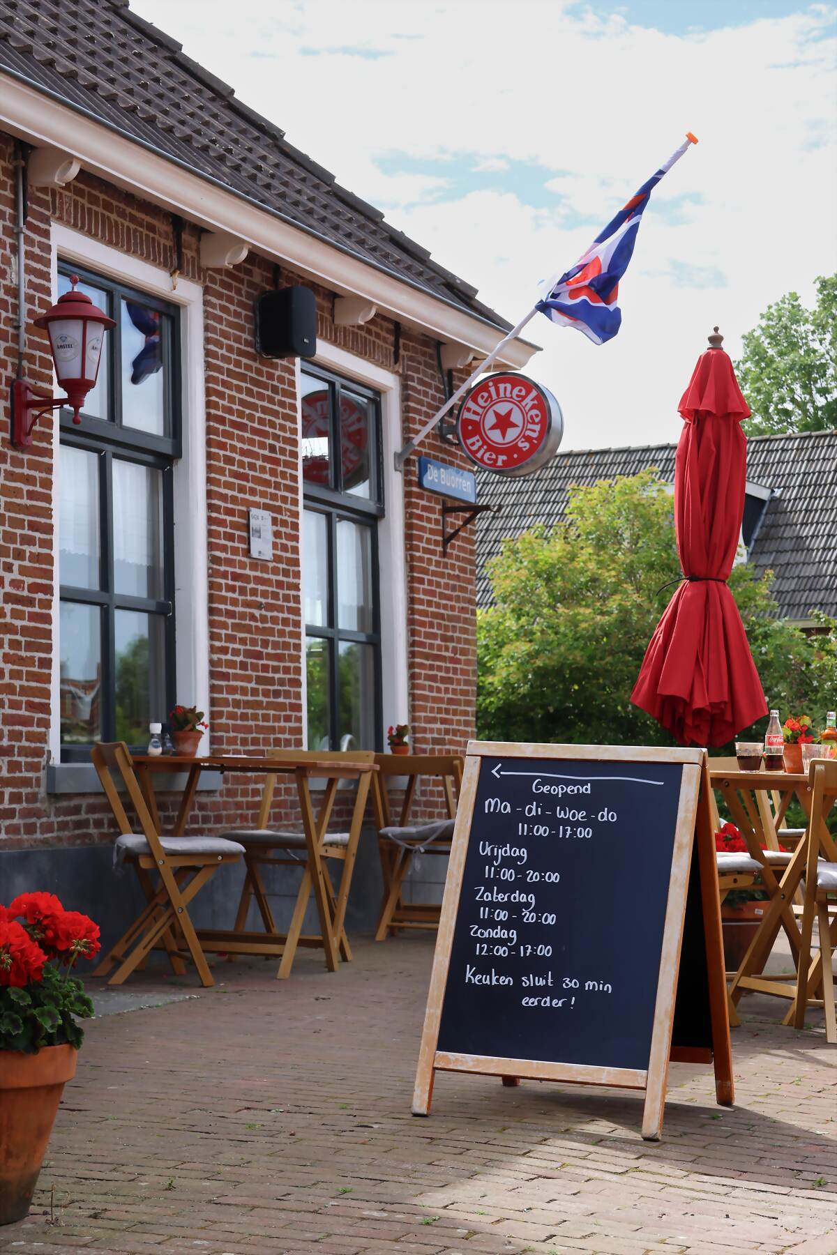 Het terras van eetkafé De Zwarte Arend aan De Buorren in Paesens, met de Friese vlag aan de gevel